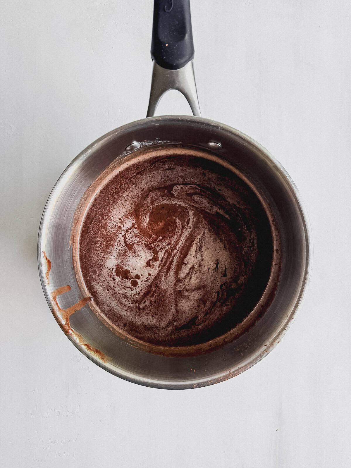 A medium saucepan with butter, cocoa, and hot water mixed together.