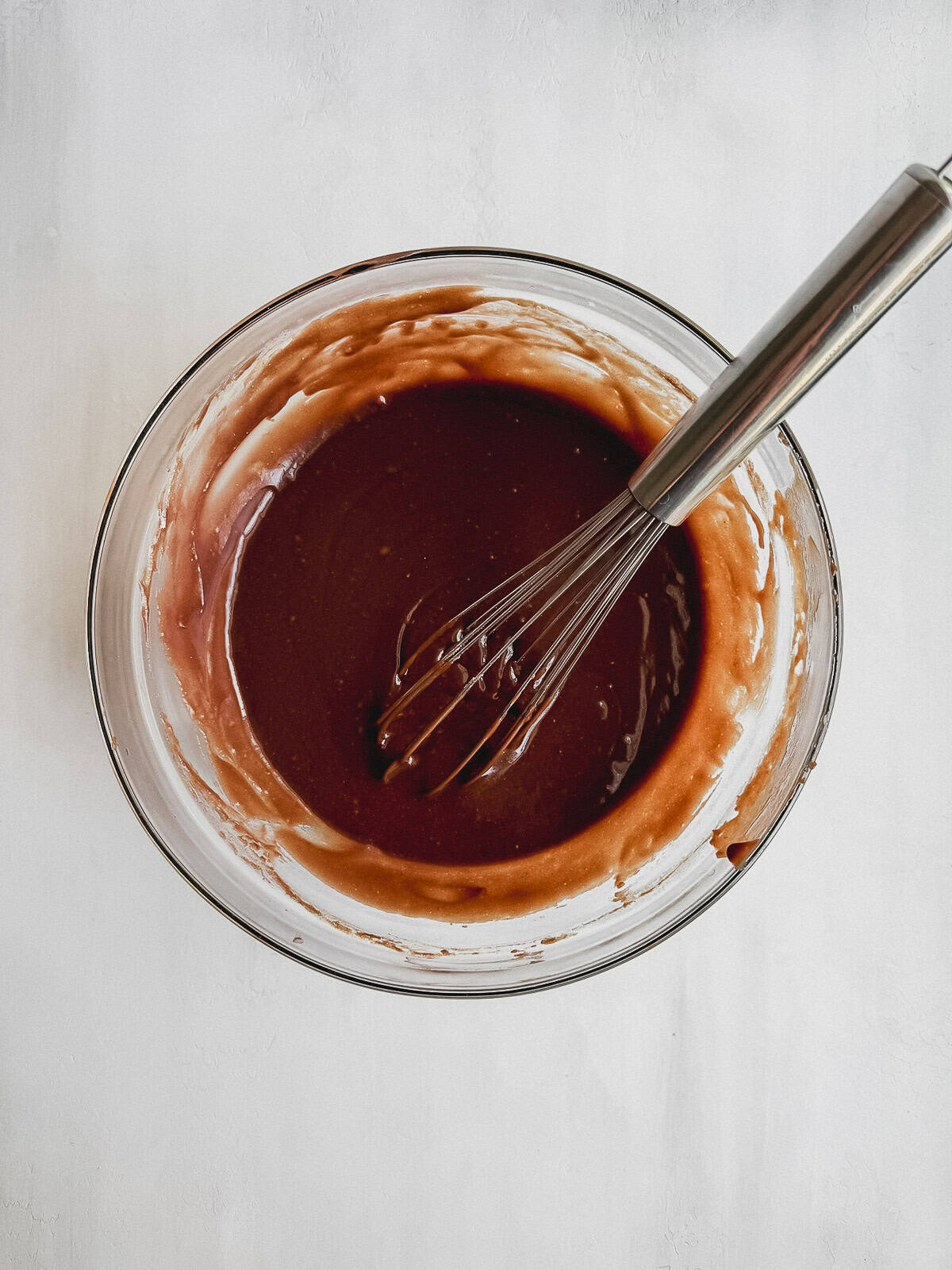 Wet ingredients in a large mixing bowl with a whisk.