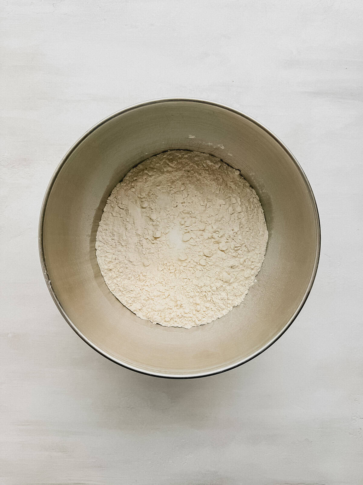 A mixing bowl with cake flour, sugar, milk powder, baking powder, baking soda, and salt.