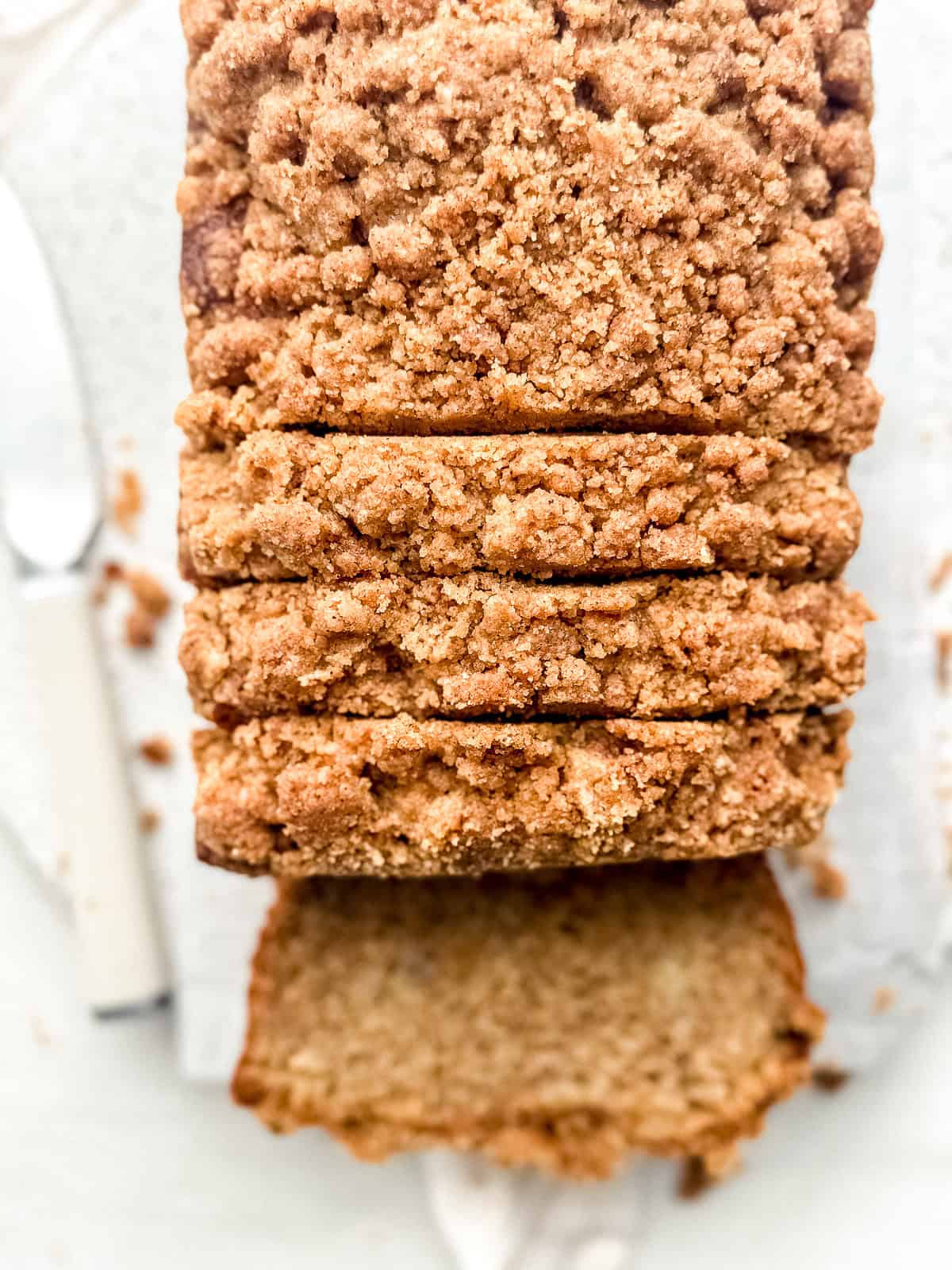 Overhead close up of sliced moist banana bread with streusel topping.