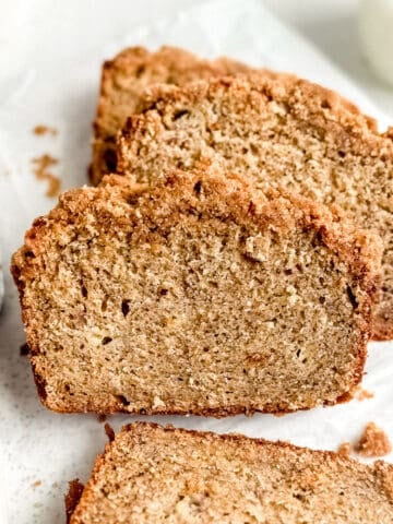 Slices of banana bread with streusel topping laying on top of each other.