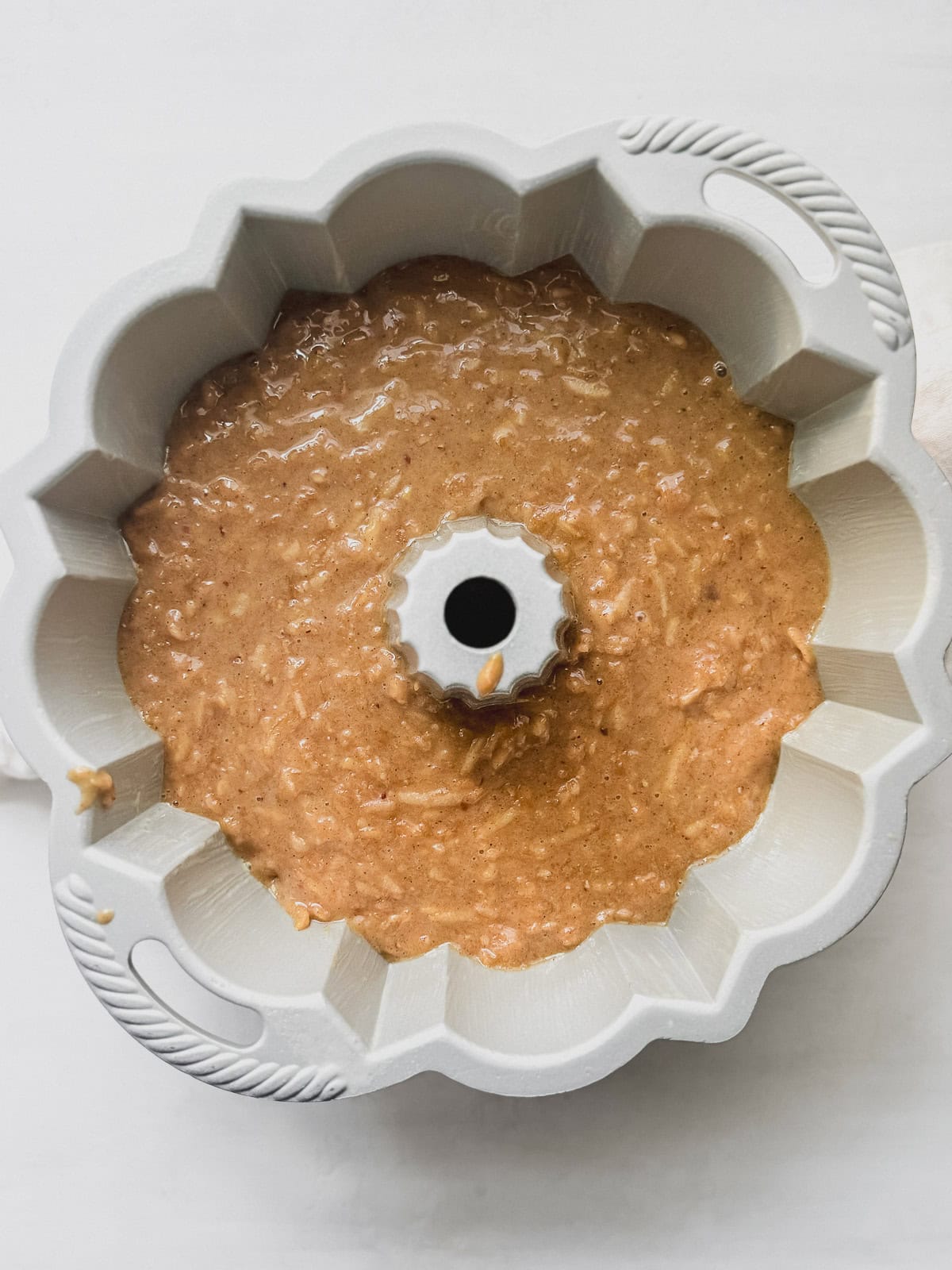 Apple pecan cake batter in a bundt pan.