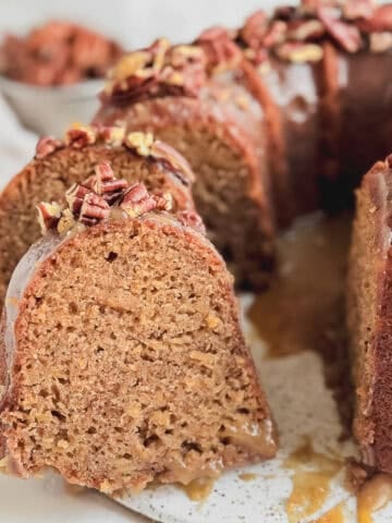 Sliced apple pecan cake on a cake plate.